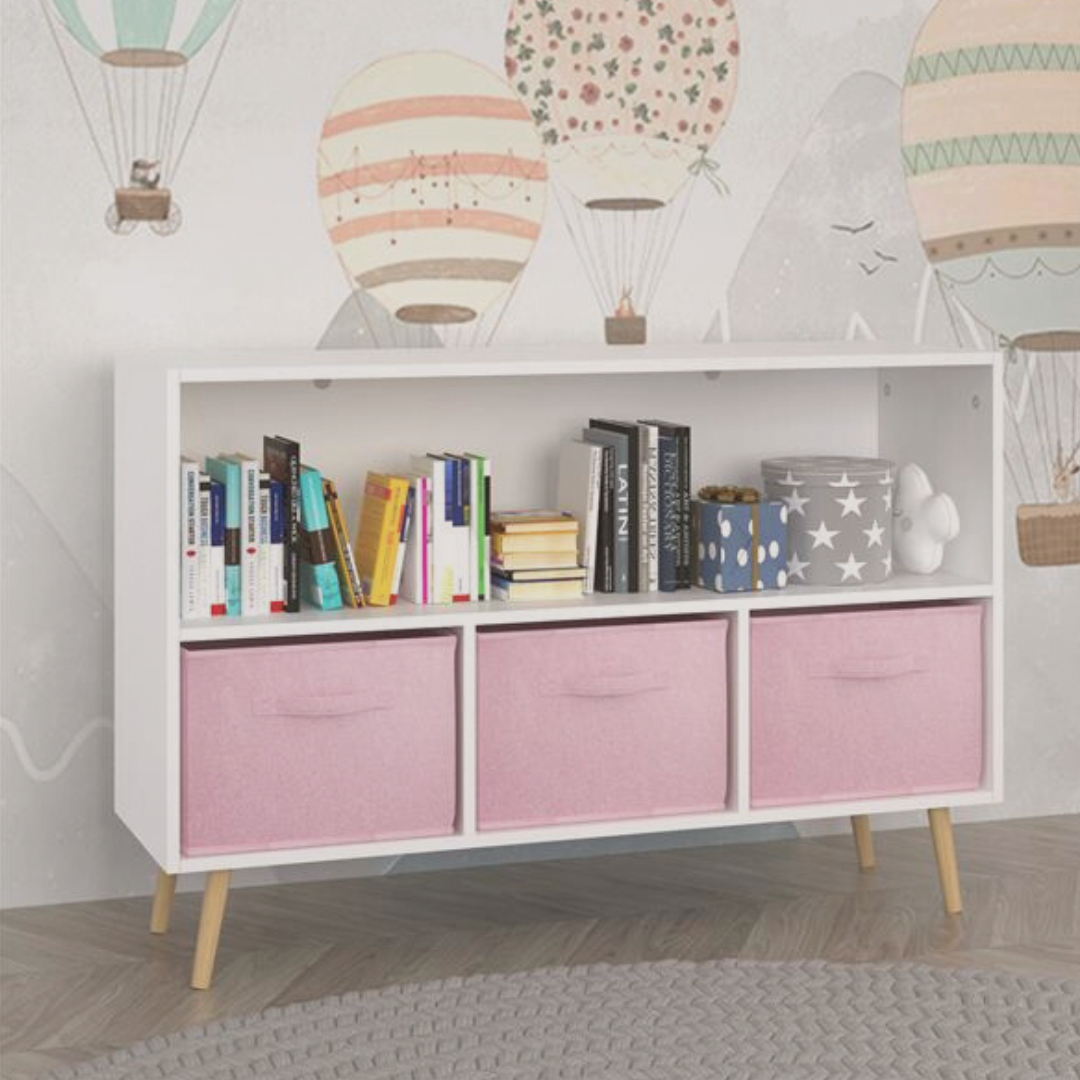 White storage unit with pink drawers in a room with hot air balloon wall art.