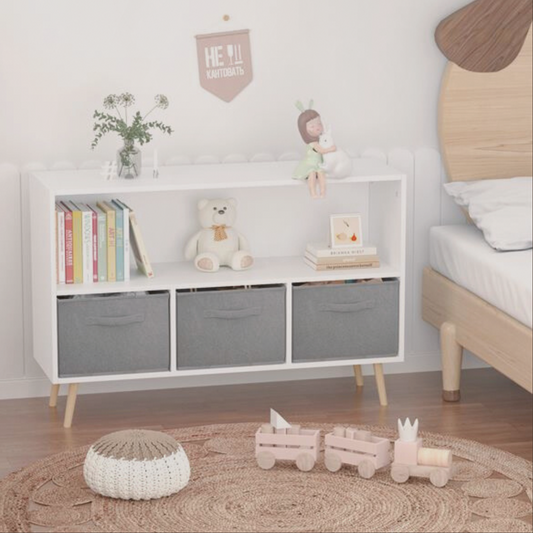 Children's room with a white storage unit, books, teddy bear, and toys on a wooden floor.